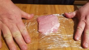 How to make Pork Schnitzel. Rip off enough plastic wrap to completely cover the pork for several inches in all directions